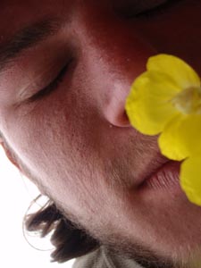 Smelling a yellow flower.