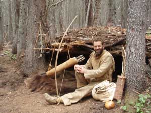 Thomas Elpel in buckskins at primitive shelter.