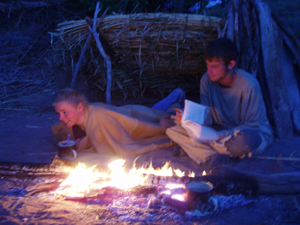 Reading and laughing by campfire.