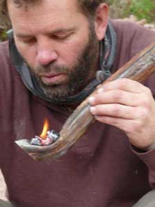 Using coals to make wooden spoon.