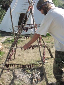 Drying deer jerky over fire.