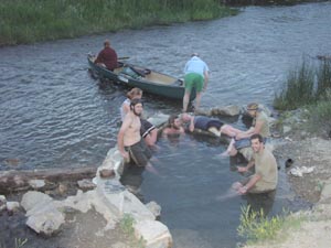 Soaking in natural river hot springs.