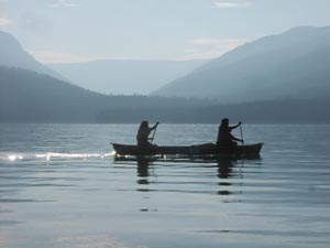 Canoeing silhouette with mountains.