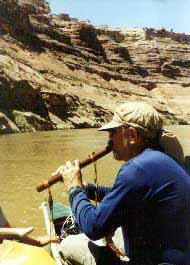 Playing flute while canoeing.